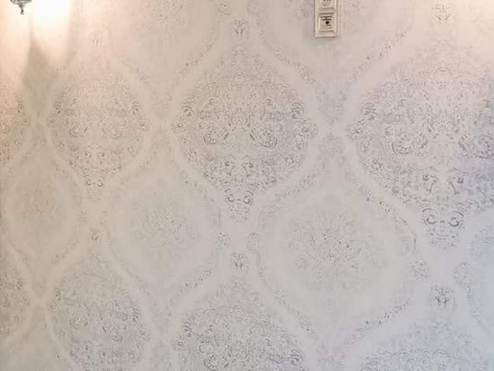 Tapezierarbeiten – elegante Mustertapete an der Wand